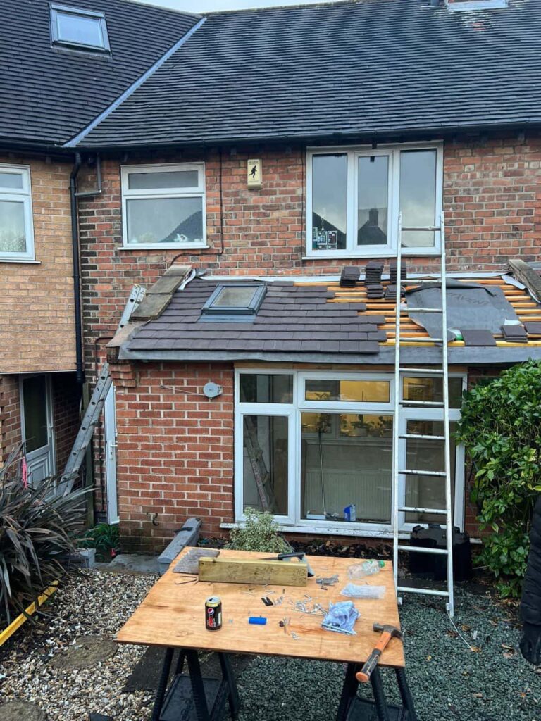 This is a photo of a roof extension that is having new roof tiles installed. This is a photo taken from the roof ridge looking down a tiled pitched roof on to a flat roof. Works carried out by Matlock Roofing Repairs